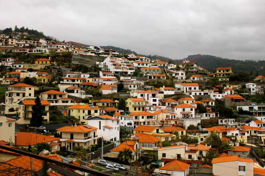 The homes on the island are mostly white-washed stone buildings with bright orange roofs.