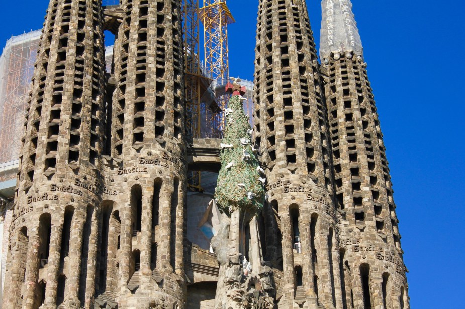 The style is Gothic + Art Nouveau, which to me, almost makes this look like something from a cartoon with its features. FYI - the Christmas Tree? It is fake and placed on top of the building during construction. This is a tradition for most construction projects in the Western Hemisphere, where the tree symbolizes the top of the structure being built...you should see this from time to time when larger buildings are being built by construction workers. The tree is removed during a "topping off" cermony when the work is complete at the top.