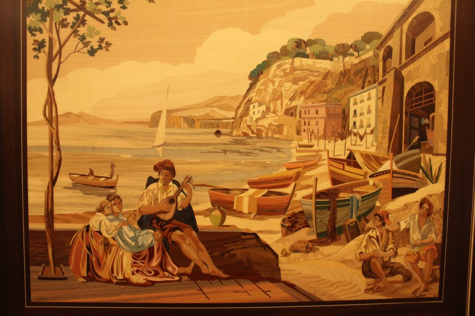 ...this is an example of a finished piece. This is not paint, but various shapes of dyed, thin wood that have been cut out and placed together to form the picture. After it is completed, it is then covered with a glaze to protect it and to give it a shine. The finished pieces are either wall art or is inlaid into the tops of tables or small boxes, etc. It is very fine craftsmanship. To give an idea of cost...this is a wall art piece maybe a 12 inches by 16 inches and it was on sale for $900.